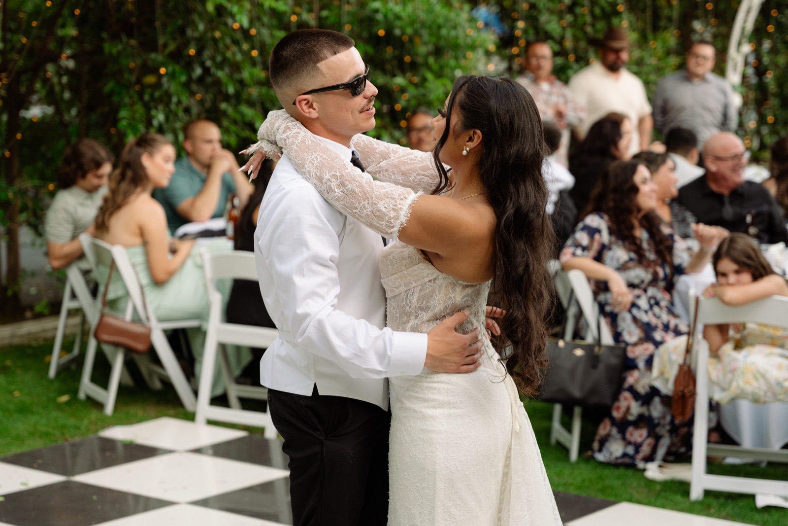 Novios bailando juntos rodeados de invitados